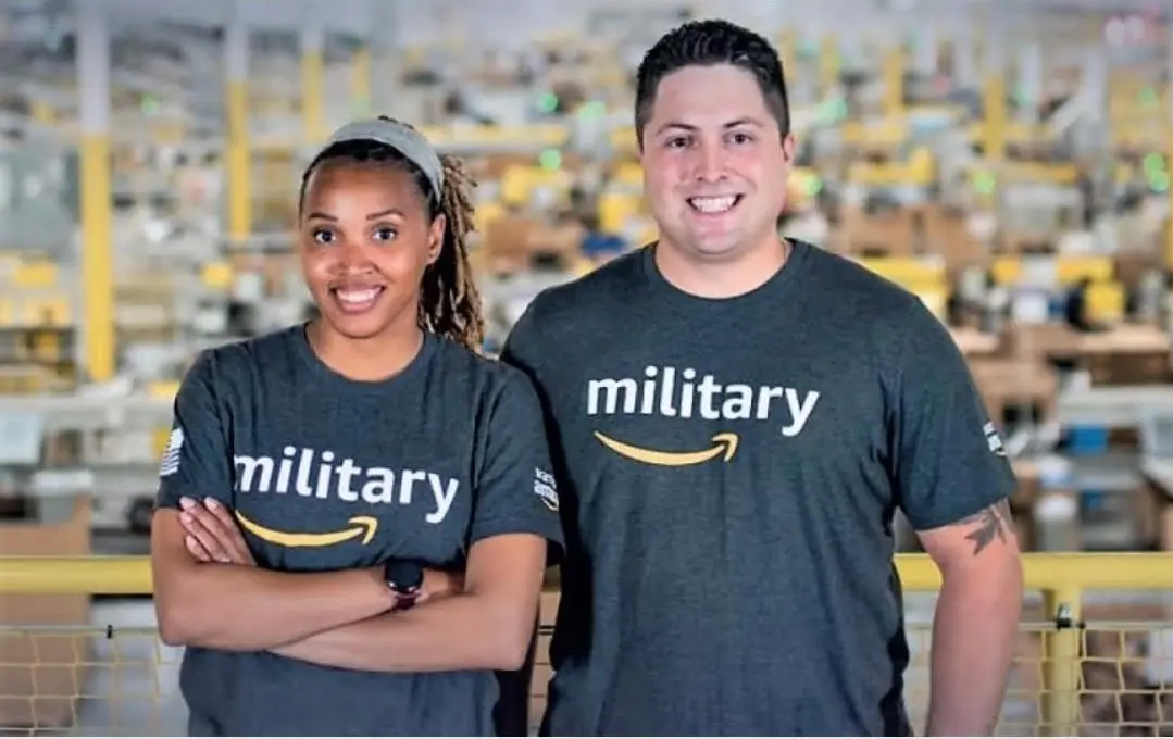 Two people wearing Amazon military shirts in a fulfillment facility.